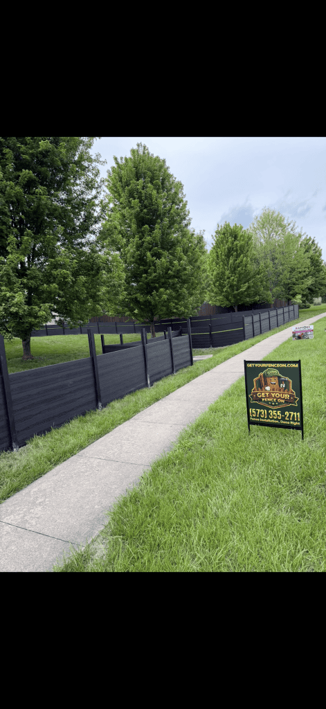 Completed dark privacy fence with the Get Your Fence On yard sign