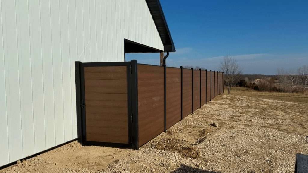 Brown horizontal privacy fence and walk gate beside a light-colored outbuilding.
