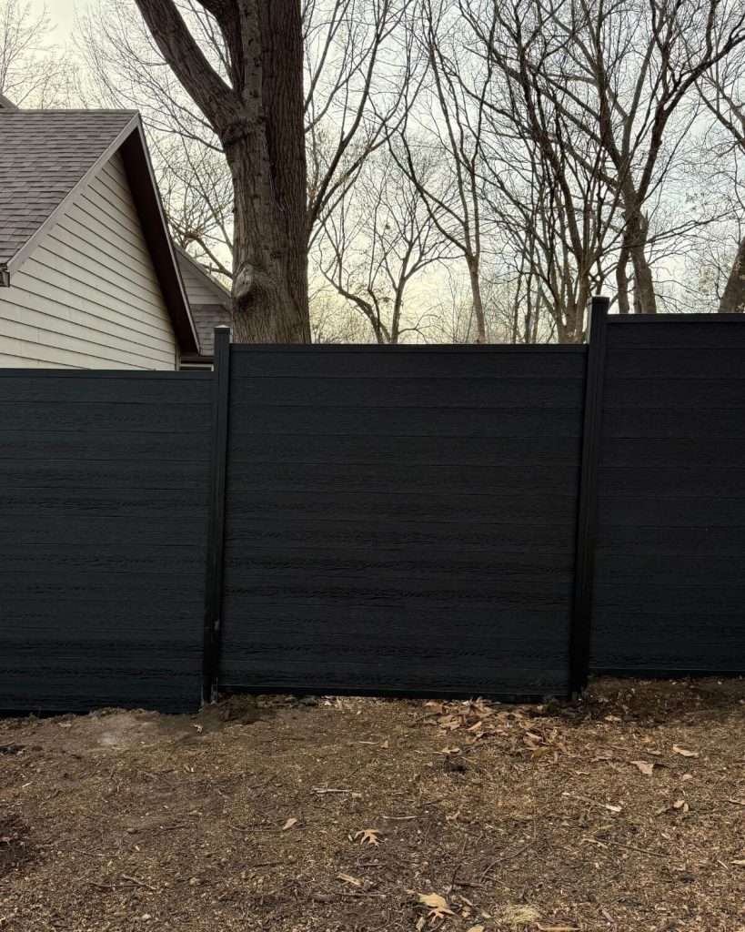 Dark horizontal privacy panels with stepped top edges beneath a large tree.