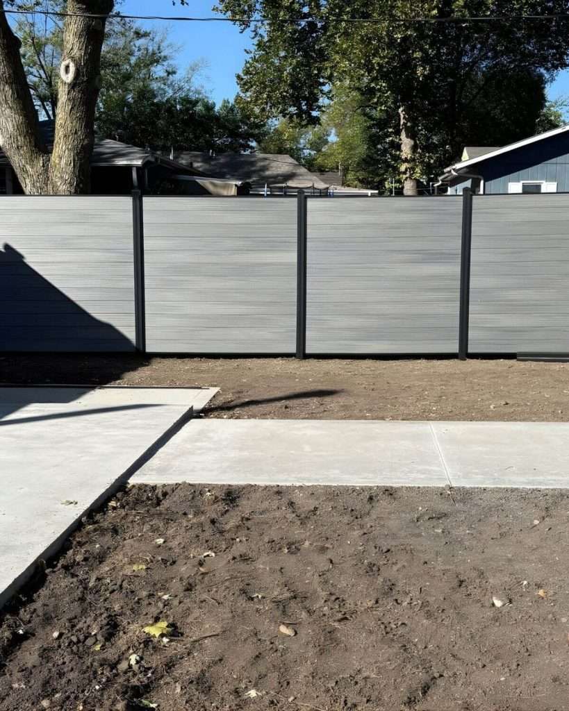 Gray horizontal privacy panels across a yard with intersecting concrete paths.